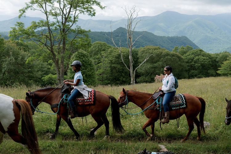 A mother/daughter horseback riding during the Cowgirl Camp at Cataloochee Ranch.
